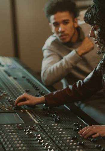 sound producers working with graphic equalizer at recording studio